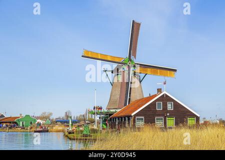 Zaanse Schans, Paesi Bassi, icona di Holland mulino a vento nel villaggio tradizionale contro cielo nuvoloso blu Foto Stock