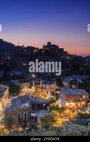 Restaurantes y iglesia parroquial de San Juan Bautista, situada en la parte alta de la villa de Deia. Sierra de Tramuntana. Maiorca. Isole Baleari. Foto Stock