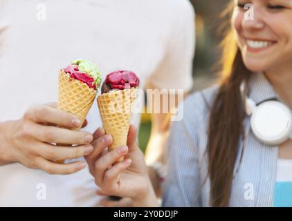 Bella giovane coppia adolescente in città vicino all'università con gelato dopo aver studiato e divertendosi insieme ridendo e sorridendo Foto Stock