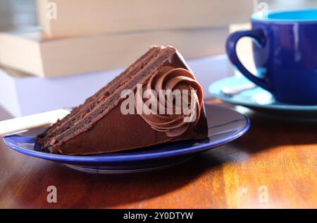 fetta di deliziosa torta al cioccolato su un piatto blu Foto Stock