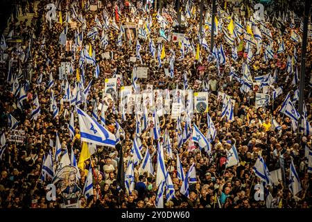 Tel Aviv, Israele. 1 settembre 2024. I manifestanti ondeggiano le bandiere durante una protesta a Tel Aviv domenica, 1 settembre 2024. Gli organizzatori sostengono che oltre 700.000 israeliani sono saliti nelle strade delle città di tutto il paese domenica sera un giorno dopo che i corpi di Carmel Gat, Eden Yerushalmi, Hersh Goldberg-Polin, Alexander Lobanov, Almog Sarusi e il Maestro Ori Danino, sono stati salvati da Gaza. I manifestanti chiesero che il primo ministro Benjamin Netanyahu raggiungesse un accordo di cessate il fuoco con Hamas per riportare a casa i prigionieri rimasti. Foto di Eyal Warshavsky. Crediti: Eyal Warshavsky/Alamy Live News Foto Stock