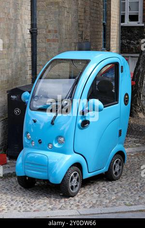 cabina scooterpac, scooter elettrico per la mobilità parcheggiato in strada, norwich, norfolk, inghilterra Foto Stock