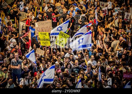 Tel Aviv, Israele. 1 settembre 2024. I manifestanti alzano i cartelli e sventolano la bandiera israeliana durante una protesta a Tel Aviv domenica 1 settembre 2024. Gli organizzatori sostengono che oltre 700.000 israeliani sono saliti nelle strade delle città di tutto il paese domenica sera un giorno dopo che i corpi di Carmel Gat, Eden Yerushalmi, Hersh Goldberg-Polin, Alexander Lobanov, Almog Sarusi e il Maestro Ori Danino, sono stati salvati da Gaza. I manifestanti chiesero che il primo ministro Benjamin Netanyahu raggiungesse un accordo di cessate il fuoco con Hamas per riportare a casa i prigionieri rimasti. Foto di Eyal Warshavsky. Crediti: Eyal Warshavsky/Alam Foto Stock