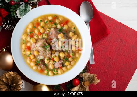 Stufato di ceci con trottole di maiale. Tavolo con vista dall'alto e decorazioni natalizie. Foto Stock