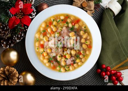 Stufato di ceci con trottole di maiale. Tavolo con vista dall'alto e decorazioni natalizie. Foto Stock