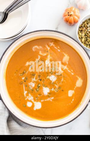 Zuppa di zucca con panna e semi in una pentola Foto Stock