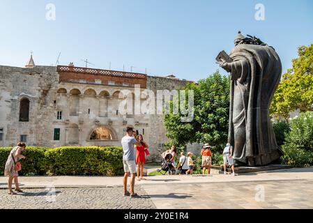 Turisti di fronte alla statua del vescovo Grgur Ninski (Gregorio di Nin), prelato cattolico croato medievale, opera dello scultore Ivan Mestrovic nel Gi Foto Stock