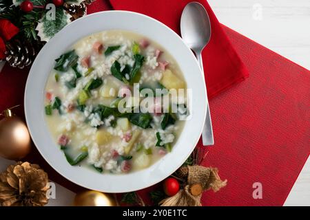 Zuppa di riso, prosciutto e spinaci, tapa spagnola tradizionale. Tavolo con vista dall'alto e decorazioni natalizie. Foto Stock