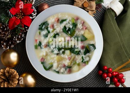 Zuppa di riso, prosciutto e spinaci, tapa spagnola tradizionale. Tavolo con vista dall'alto e decorazioni natalizie. Foto Stock