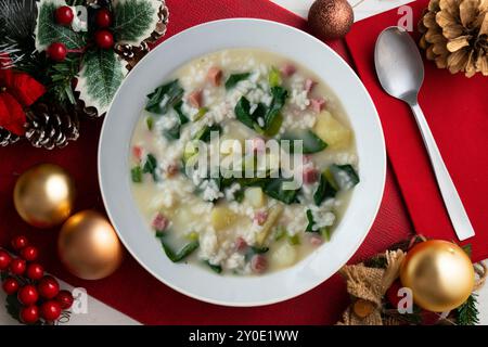 Zuppa di riso, prosciutto e spinaci, tapa spagnola tradizionale. Tavolo con vista dall'alto e decorazioni natalizie. Foto Stock