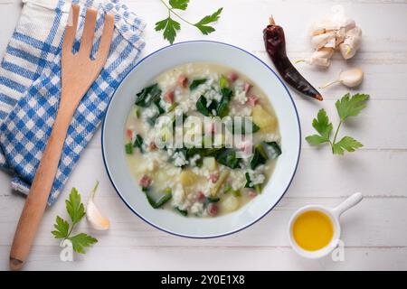 Zuppa di riso, prosciutto e spinaci, tapa spagnola tradizionale. Tavolo con vista dall'alto e decorazioni. Foto Stock