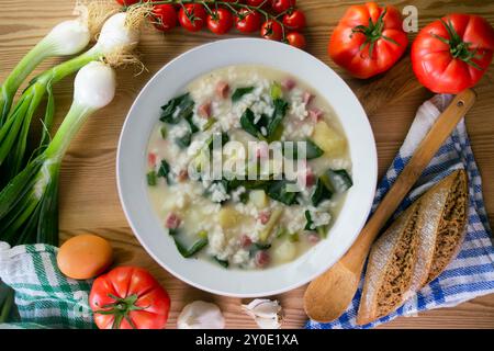 Zuppa di riso, prosciutto e spinaci, tapa spagnola tradizionale. Tavolo con vista dall'alto e decorazioni. Foto Stock