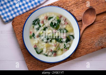 Zuppa di riso, prosciutto e spinaci, tapa spagnola tradizionale. Tavolo con vista dall'alto e decorazioni. Foto Stock