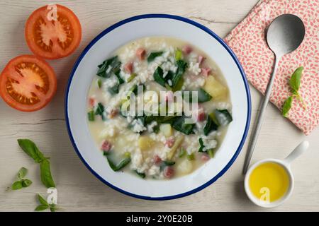 Zuppa di riso, prosciutto e spinaci, tapa spagnola tradizionale. Tavolo con vista dall'alto e decorazioni. Foto Stock