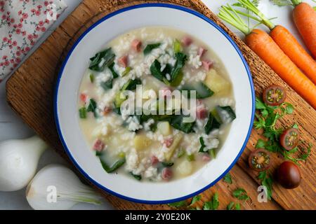 Zuppa di riso, prosciutto e spinaci, tapa spagnola tradizionale. Tavolo con vista dall'alto e decorazioni. Foto Stock