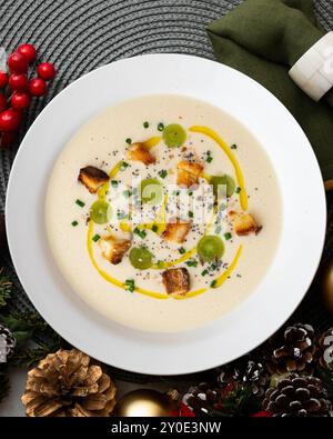 Zuppa spagnola di tapa fredda di ajoblanco con uva. Tavolo con vista dall'alto e decorazioni natalizie. Foto Stock