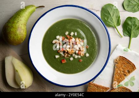 Crema di spinaci a base di pera, verdure e noci. Tavolo con vista dall'alto e decorazioni natalizie. Foto Stock