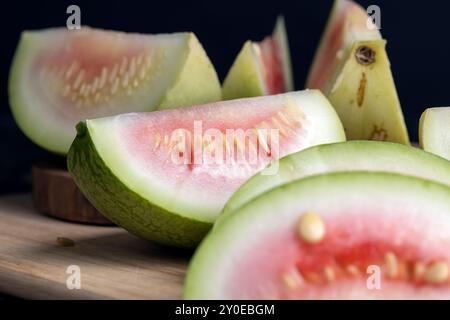 tagliare il cocomero non maturo su una tavola, tagliarlo a pezzi di piccole dimensioni Foto Stock