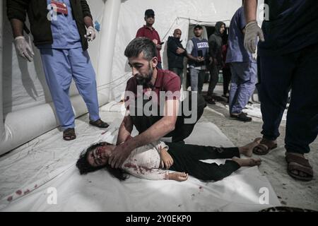 Gaza, Palestina. 12 ottobre 2023. Un bambino ucciso nel pesante bombardamento israeliano in corso nella Striscia centrale di Gaza viene portato all'ospedale Shuhada al-Aqsa di Deir al-Balah. La famiglia Nufal è stata pesantemente colpita dagli ultimi bombardamenti israeliani, con organizzazioni umanitarie che hanno messo in luce le pesanti vittime tra i bambini di Gaza a causa degli attacchi indiscriminati di Israele nella Striscia di Gaza Foto Stock