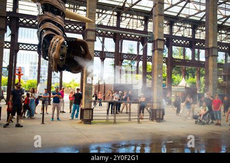 Il tronco del grande Elefante spruzza acqua sulle persone nella Galleria Machine de l'Ile di Nantes, Francia. Foto Stock