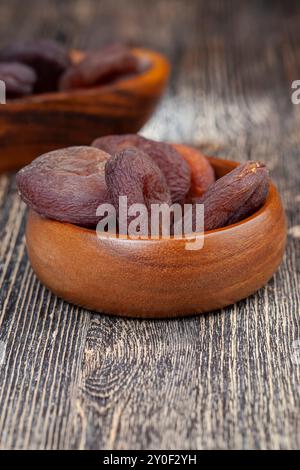 una piccola quantità di albicocche secche morbide di colore scuro, albicocche secche e altre noci e frutta secca sul tavolo Foto Stock