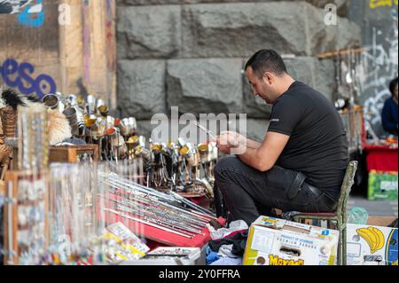 Tbilisi, Georgia - 6 ottobre 2023: L'artigianato espone gioielli fatti a mano mentre interagisce con i clienti in un mercato vivace. Foto Stock