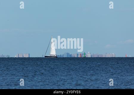 South Amboy, New Jersey - 21 agosto 2024: Le barche a vela navigano nella baia di Raritan durante le loro corse del mercoledì sera nell'estate del 2024 Foto Stock