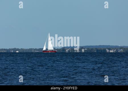 South Amboy, New Jersey - 21 agosto 2024: Le barche a vela navigano nella baia di Raritan durante le loro corse del mercoledì sera nell'estate del 2024 Foto Stock