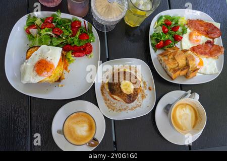 brunch con tavolino da caffè con prosciutto e uova, croque madame e bagel. Foto Stock