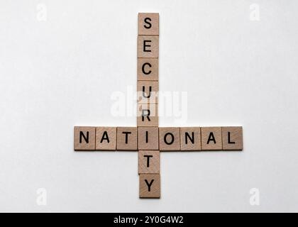 Primo piano di piastrelle di legno che formano un puzzle di parole incrociate con le parole "nazionale" e "sicurezza" - concetto di sicurezza e protezione nazionale Foto Stock