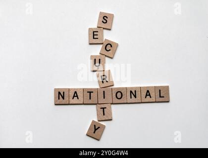 Primo piano di piastrelle di legno che formano un puzzle di parole incrociate con le parole "nazionale" e "sicurezza" - concetto di sicurezza e protezione nazionale Foto Stock