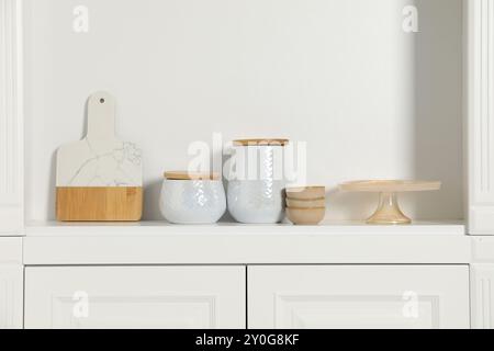 Scaffalature bianche con diversi utensili da cucina all'interno Foto Stock