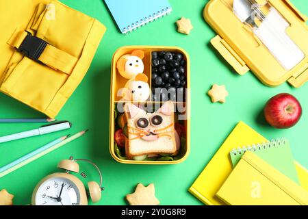 Composizione piatta con pranzo al sacco e spuntini sul tavolo verde Foto Stock