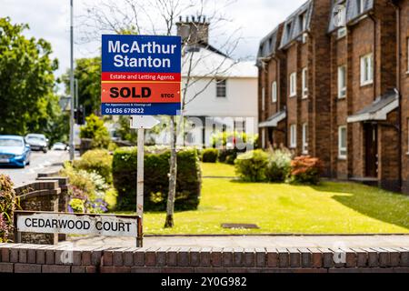 McArthur Stanton Real Estate, o cartello per la vendita con STCC venduto attraverso di esso, in un quartiere residenziale periferico scozzese (UK) Foto Stock