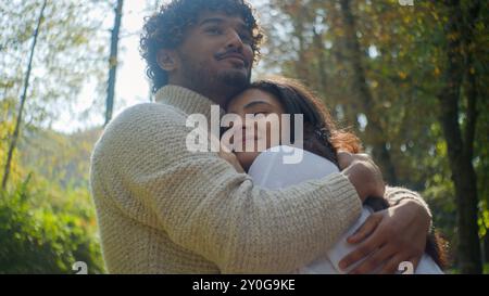 Spensierato arabo indiano affettuoso coppia sorridente donna uomo ragazzo maschio abbracciare ragazza moglie marito godere vicinanza in parco romantico Foto Stock