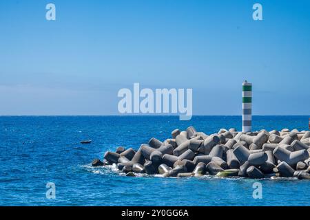 Funchal Madeira Island giu' vicino al porto e alla banchina del porto di Funchal grandi massi di cemento e blocchi che proteggono le alte maree dall'ingresso Foto Stock