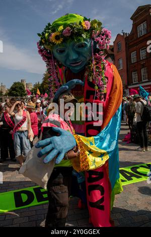 Windsor, Regno Unito, 1 settembre 2024. Un burattino gigante patta un dimostratore della ribellione dell'estinzione sulla testa. I membri della Extinction Rebellion tengono una dimostrazione di tre giorni fuori dal castello di Windsor. Il gruppo chiede al nuovo governo laburista di istituire un'assemblea dei cittadini per affrontare il cambiamento climatico. Crediti: James Willoughby/Alamy Live News Foto Stock