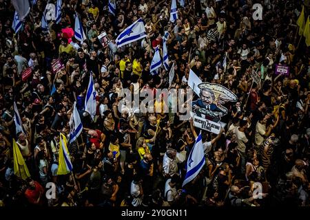 Tel Aviv, Israele. 1 settembre 2024. I manifestanti reggono la bandiera israeliana durante la manifestazione. Gli organizzatori sostengono che oltre 700.000 israeliani sono saliti nelle strade delle città di tutto il paese domenica sera un giorno dopo che i corpi di Carmel Gat, Eden Yerushalmi, Hersh Goldberg-Polin, Alexander Lobanov, Almog Sarusi e il Maestro Ori Danino, sono stati salvati da Gaza. I manifestanti chiesero che il primo ministro Benjamin Netanyahu raggiungesse un accordo di cessate il fuoco con Hamas per riportare a casa i prigionieri rimasti. (Foto di Eyal Warshavsky/SOPA Images/Sipa USA) credito: SIPA USA/Alamy Live News Foto Stock