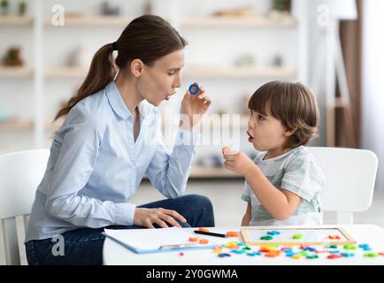 Terapista del parlato femminile che cura i problemi e gli impedimenti del bambino. O con un tutor privato Foto Stock