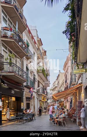 Sitges, Barcellona - 01 settembre 2024: La luce naturale illumina i dettagli architettonici che adornano questa trafficata strada commerciale situata nel cuore Foto Stock