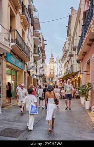 Sitges, Barcellona - 01 settembre 2024: Il mix di turisti e locali in questa strada di Sitges crea un'atmosfera vibrante e accogliente. Foto Stock