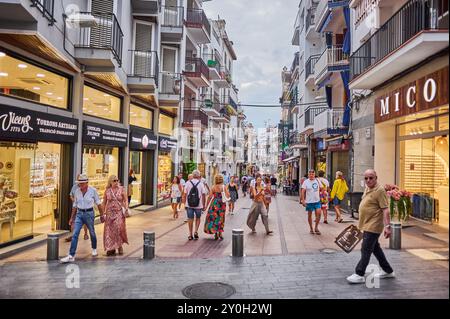 Sitges, Barcellona - 01 settembre 2024: Un gruppo chatta animatamente, mettendo in evidenza l'atmosfera amichevole che si vive quotidianamente nella strada pedonale Foto Stock