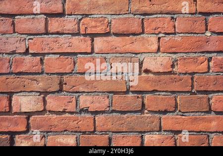 Foto di una vecchia parete, sfondo o texture in mattoni intemprati. Foto Stock