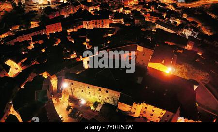 Vista aerea della piccola città che illumina la notte con luci calde Foto Stock