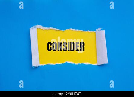 Considerare il messaggio scritto su carta strappata blu con sfondo giallo. Simbolo concettuale da considerare. Copia spazio. Foto Stock