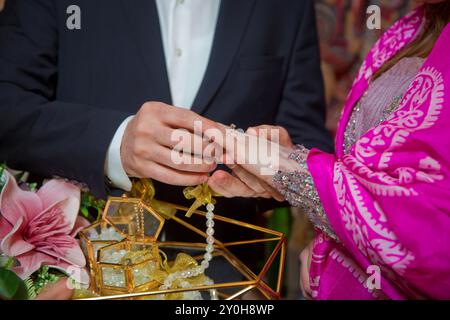 Gli sposi si scambiano anelli, lo sposo mette l'anello sulla mano della sposa nell'ufficio del registro dei matrimoni. Le spose indossano un anello sulla mano della sposa. ING Foto Stock