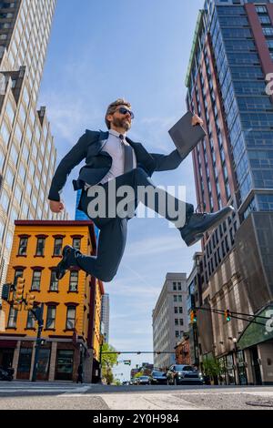 Uomo d'affari che salta per strada. Avanti salto e passi. Concetto di ambizioni aziendali. Strategia di successo aziendale. Sviluppo della crescita creativa Foto Stock