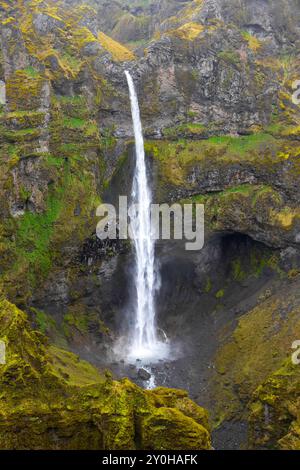 Cascata Hangandifoss nel Mulagljufur Canyon nel sud dell'Islanda con formazioni rocciose vulcaniche ricoperte di muschio. Foto Stock