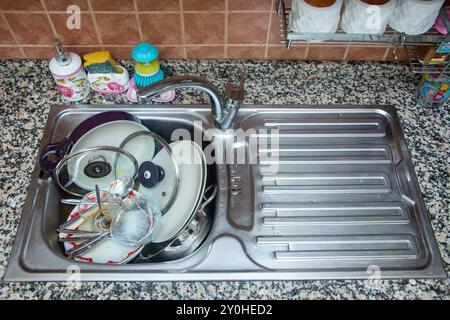 Vista alta dei piatti sporchi nel lavandino della cucina di casa Foto Stock