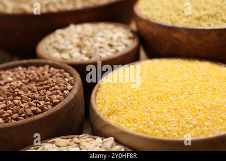 Diversi tipi di cereali in ciotole a tavola, primo piano Foto Stock